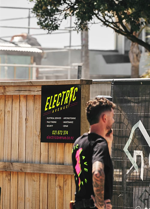 Electrician answering phone call in Tauranga suburb.